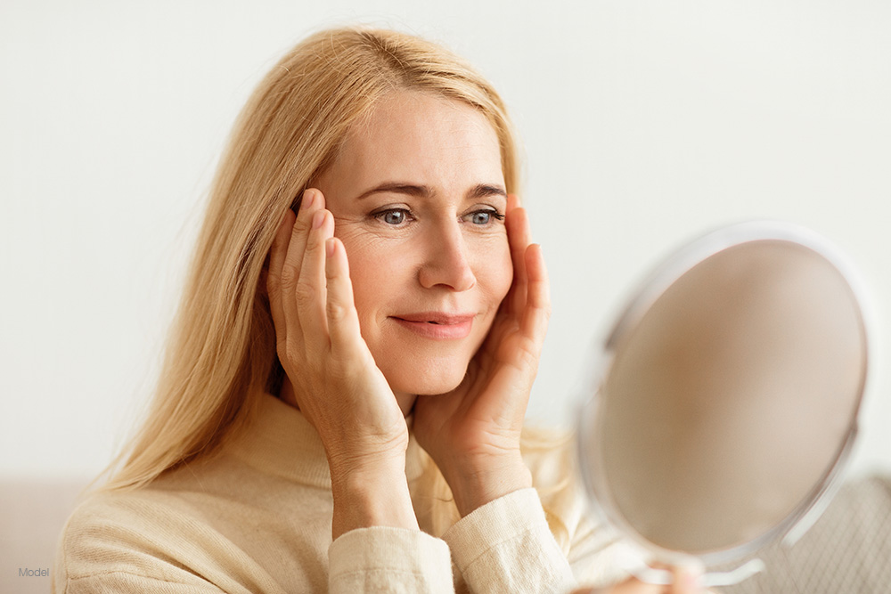 Mature woman looking at herself in the mirror